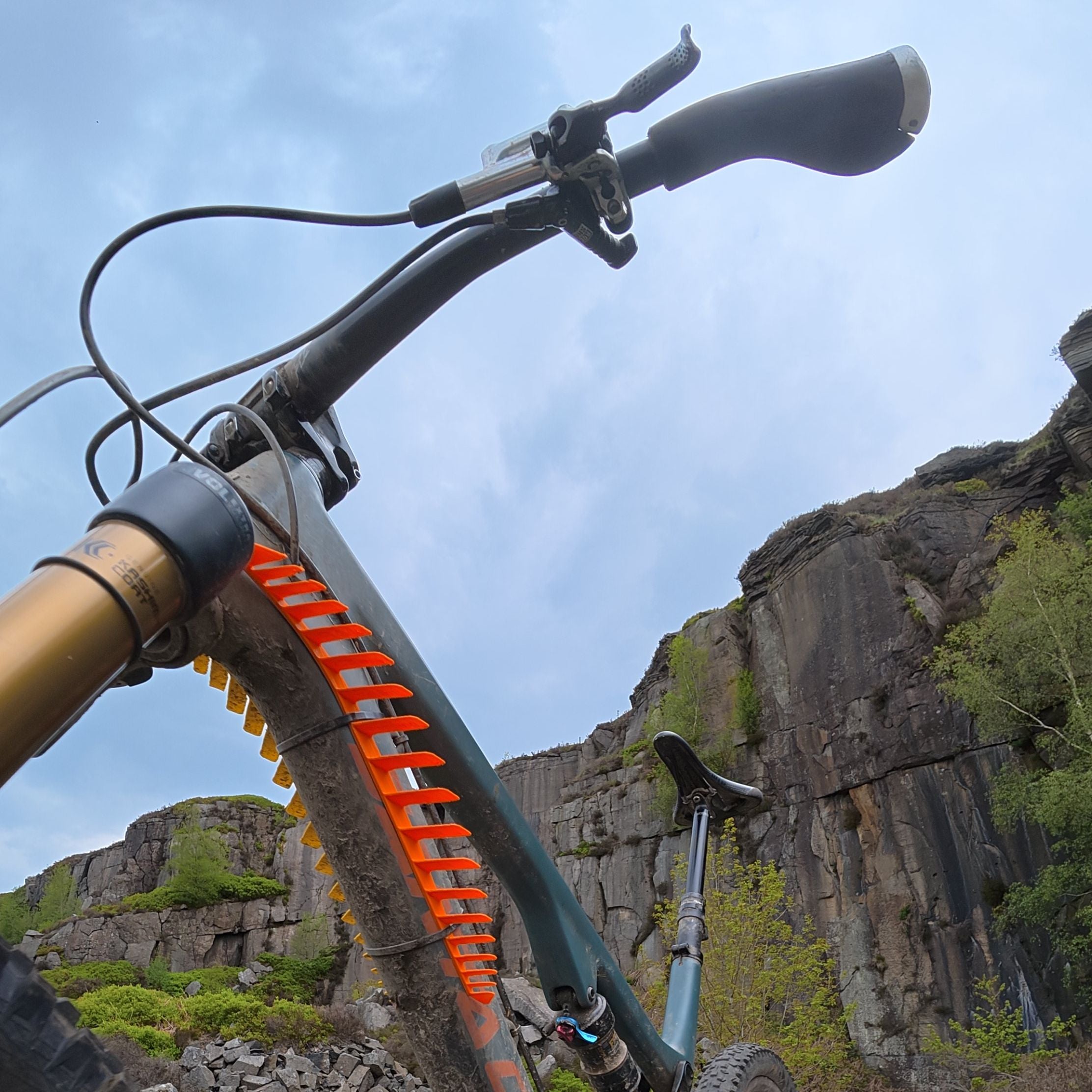CombOver MTB mudguard in orange in front of rocky cliffs